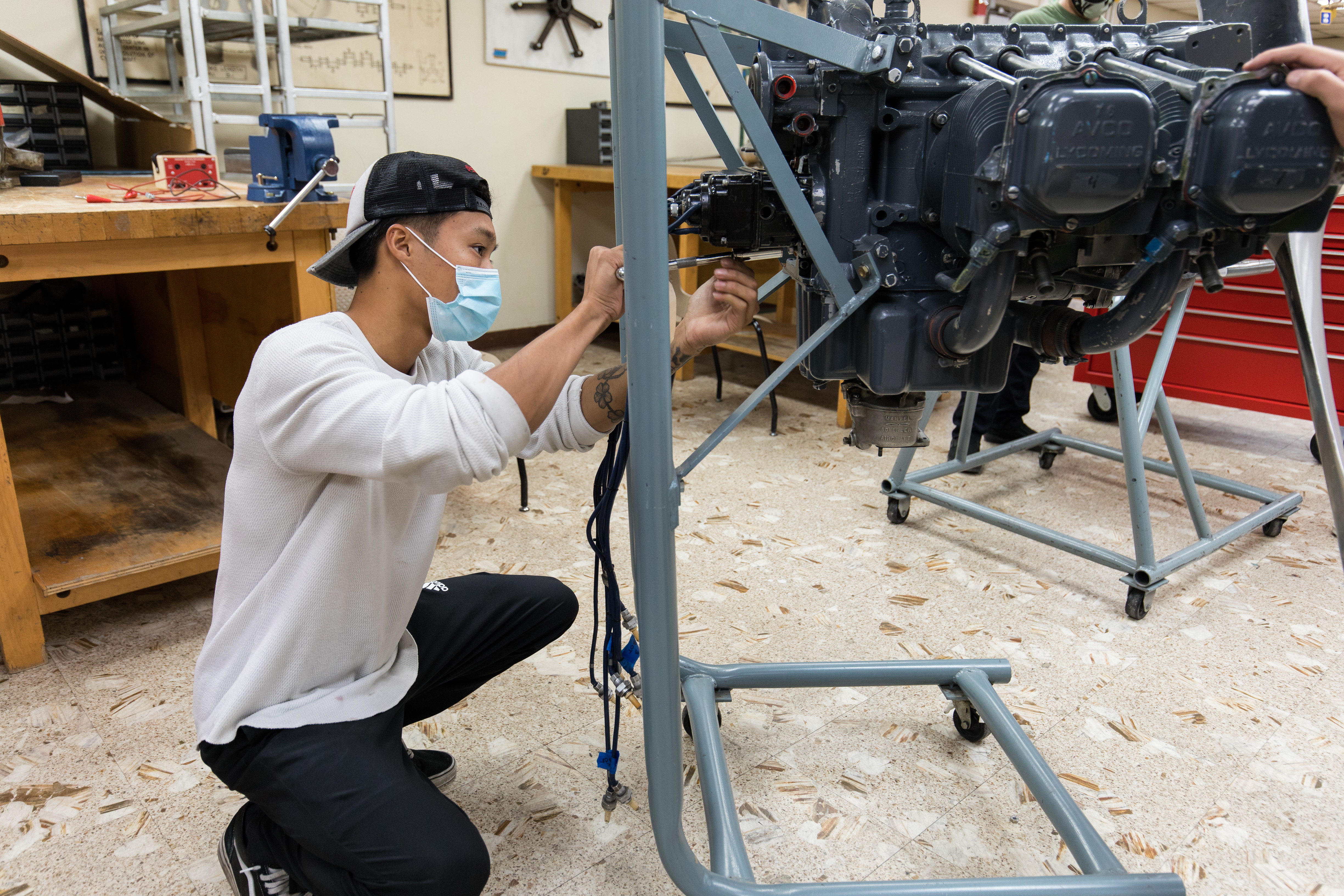 Student working on airplane image with tools.