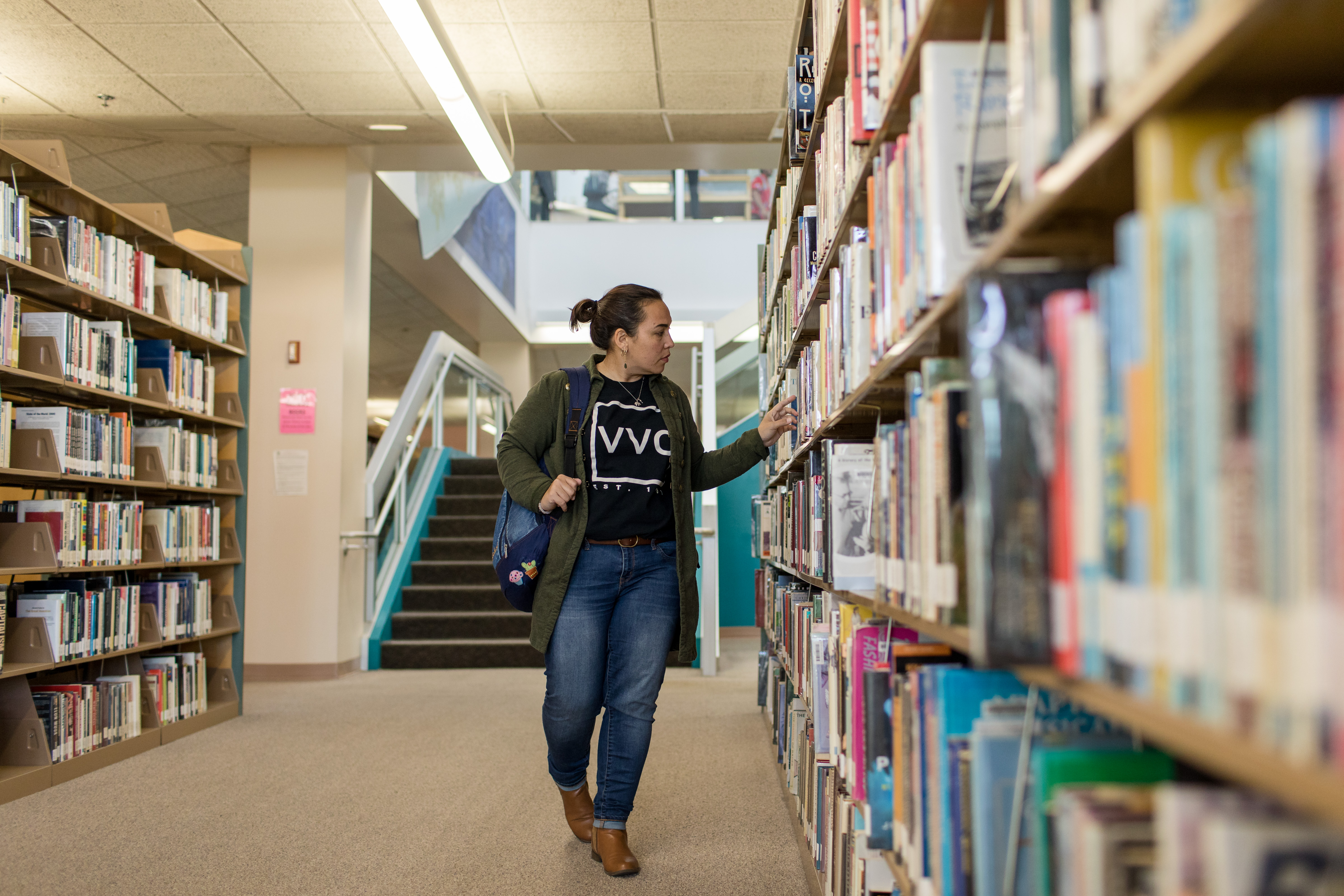 Student looking at books in the library.