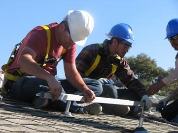 Photovoltaic Students installing roof mounts for solar equip Photovoltaic Students installing roof mounts for solar equip